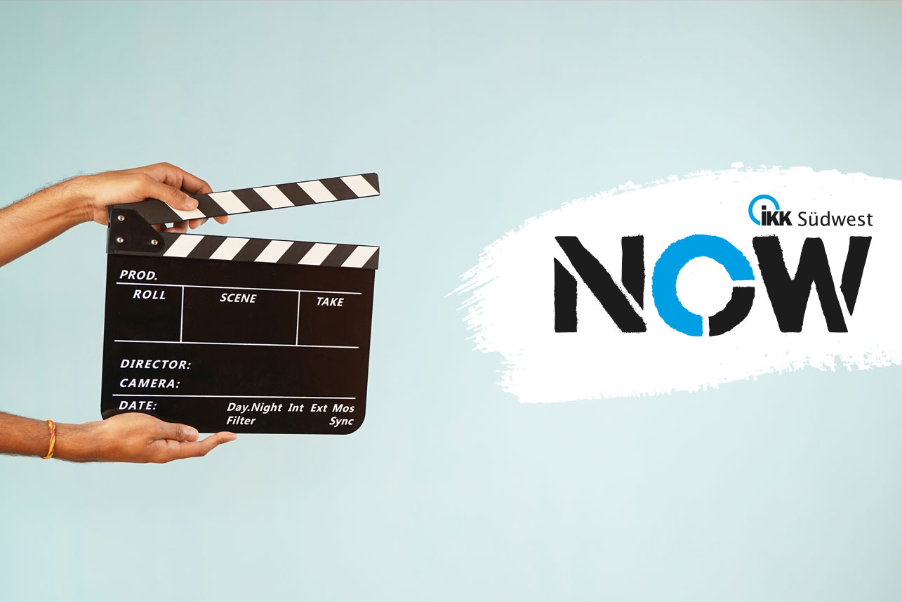 Vor hellblauem Hintergrund wird eine Filmklappe gehalten. Rechts ist in kräftigem Schwarz und Blau ein weißer Pinselstrich mit der Aufschrift „IKK NOW“ zu sehen.